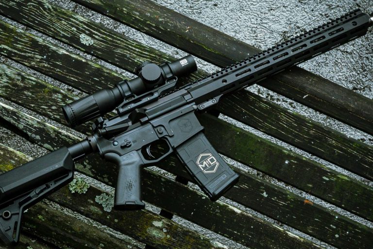 SOIDC DOC AR15 with scope leaned against wood bench