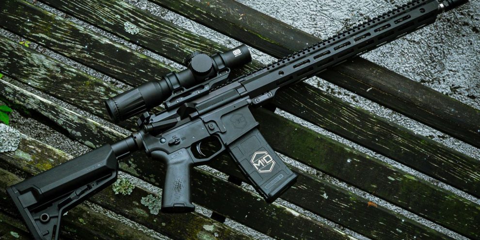 SOIDC DOC AR15 with scope leaned against wood bench